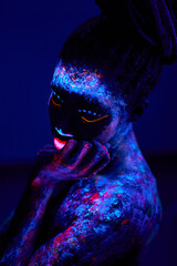 black fantastic woman Native American with neon makeup, made of fluorescent paint in ultraviolet...