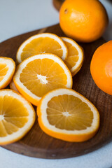 Naklejka na ściany i meble Slices of orange juicy orange on a cutting wooden board. Sliced fruit. Vitamins.