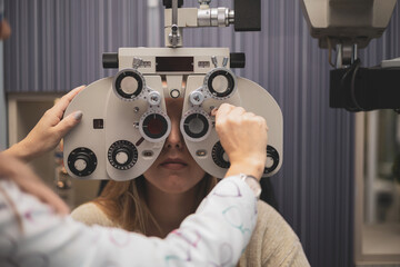 an optometrist regulates a phoropter for use by a patient.