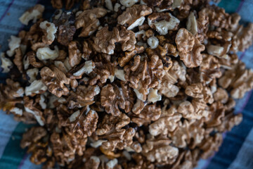 Woman cracking walnuts with hammer, Cracked brown walnut shells and stone, cracked walnut shell texture