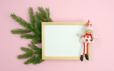 Fir branch, empty frame and chrysalis on a pink background. New Year and Christmas card, poster with place for text.