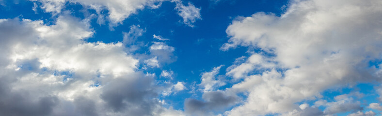 Picturesque blue sky with white fluffy clouds in sunny weather