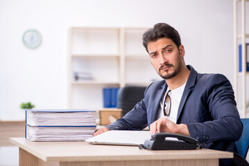 Young handsome employee working in the office