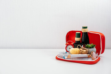 Self Care Kit, Self Care Package. Cosmetics bottles, face massager, sweets, headphones, scented candle and pencils for paint in red first aid kit. Devices for beauty, self care and leisure activities