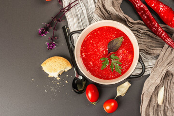 Vegan food, spicy tomato gazpacho soup with toasts, ripe vegetables, and fresh basil herbs
