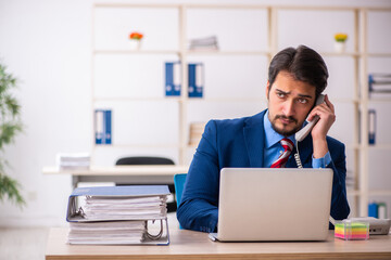 Young male employee sitting at workplace