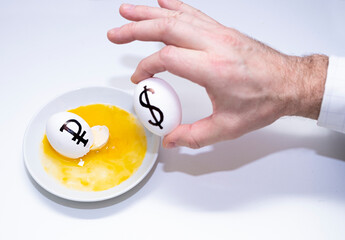 Male hands, businessman holds eggs with dollar symbols and breaks the Russian ruble