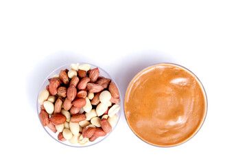 Fototapeta na wymiar Peanut butter isolated and peanuts in the peel scattered on the white background. Copy space.