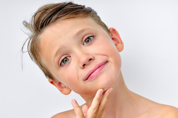 Happy, smiley little caucasian boy isolated on white studio background with copyspace for ad. Looks happy, cheerful, touching clean facial skin.Childhood, human emotions, facial expression concept.