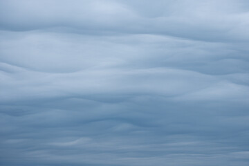 bright and dark blue and grey clouds in the sky looking like soft waves in the ocean. rare weather...