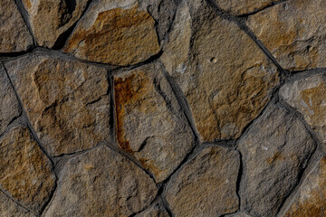 Red stone texture. Background from gray ancient stones in the rays of hard light Close up,