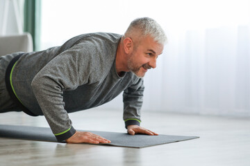 Fototapeta na wymiar Closeup of elder man exercising at home