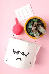 Concept of healthcare with hemorrhoids accessories on pink background