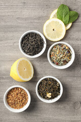 Concept of cooking tea with different types of tea on gray wooden background