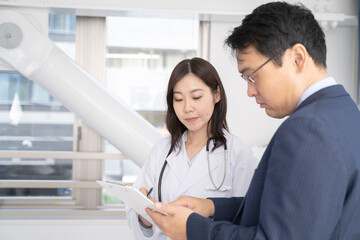 女医と打ち合わせをする男性ビジネスマン