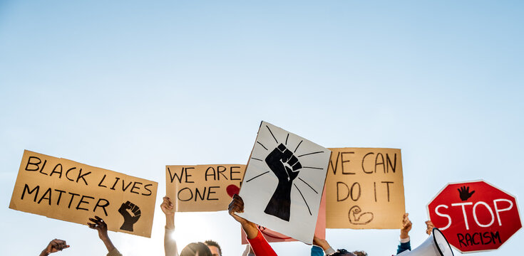 People standing with posters with inscription Black Lives Matter on meeting