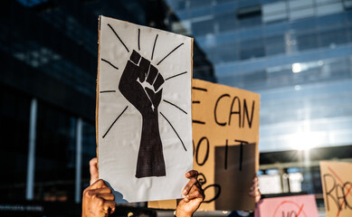 Crowd of people standing with signboards against racism on city street