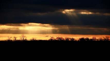 Sunbeams breaking through cloud cover in backlit shot