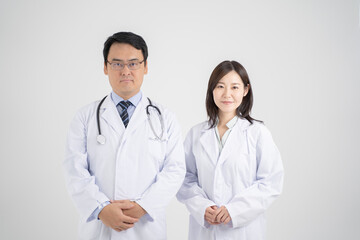 Fototapeta premium 手を前で組む男女の医師・白背景