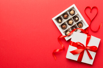 Delicious chocolate pralines in red box for Valentine's Day. Heart shaped box of chocolates top view with copy space