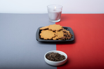 A pile of home made gingerbread cookies on a plate against festive background.