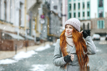 Lovely redhead lady walking at the city during new year vacation