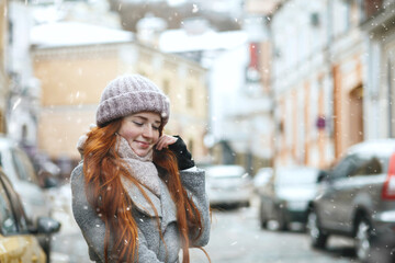 Fototapeta premium Stunning redhead lady walking at the city during new year vacation