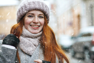 Elegant redhead lady walking at the city during new year vacation