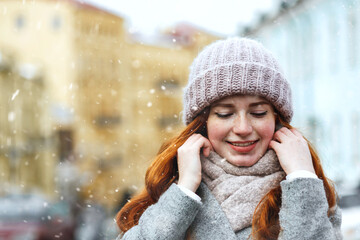 magnificent ginger lady walking at the old city with snowflakes