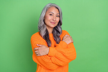 Photo of sweet grey hairdo old lady hug herself wear sweater isolated on green background