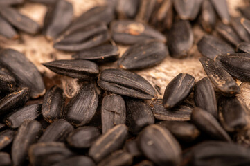 Fried black sunflower seeds scattered on the table, close-up, selective focus.