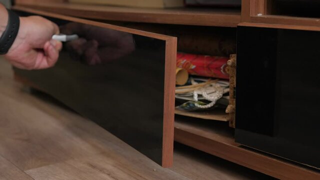 Close-up of a broken shelf in a closet, a man pushes a broken shelf in a low-quality closet. Old broken furniture.