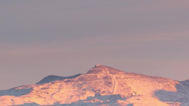 Snowy Sierra nevada veleta peak in Granada, Andalusia, Spain during sunset timelapse