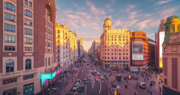 Day to night time lapse of Gran Via street in Madrid, Spain. Crowd and traffic on main street during sunset wide angle aerial point of view
