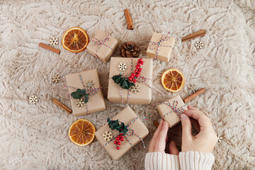 Zero waste Christmas flat lay. Hands holding simple christmas gift. Plastic free sustainable lifestyle