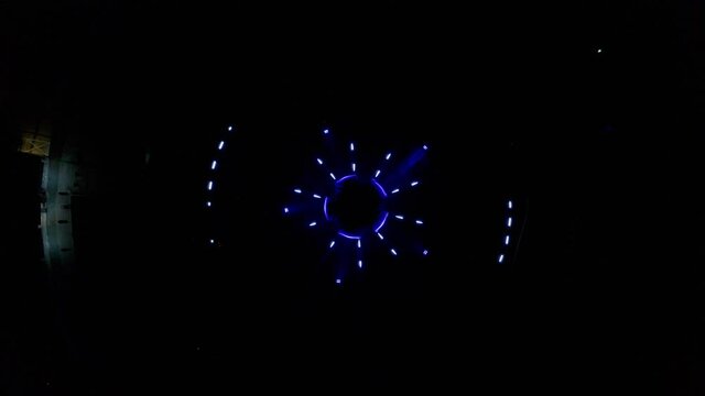 Aerial descending drone footage of an abstract and colourful circle led lights show placed in a fountain in Bratislava, Slovakia.