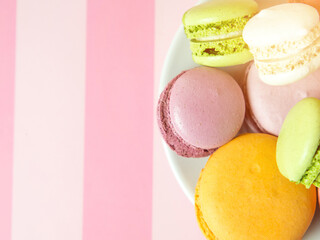 Fresh baked colored macaroon cookies macarons, macarons on a white plate close-up,