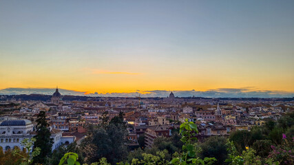 Fototapeta na wymiar Beautiful sunset over Vatican city and Rome. Rooftops seen from Villa Medici