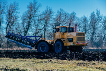 the tractor plows the land

