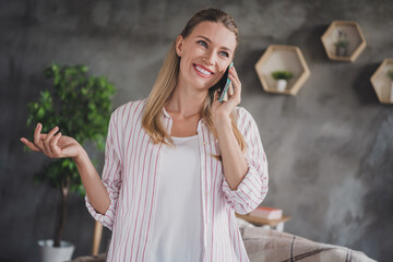 Photo of optimistic young blond lady talk telephone wear white shirt at home in living room alone