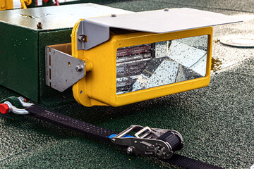 A searchlight for illumination of the helipad. Next to the belt lock for screed helicopter mesh locking wheels.