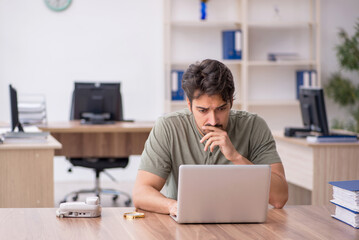 Young male employee sitting at workplace