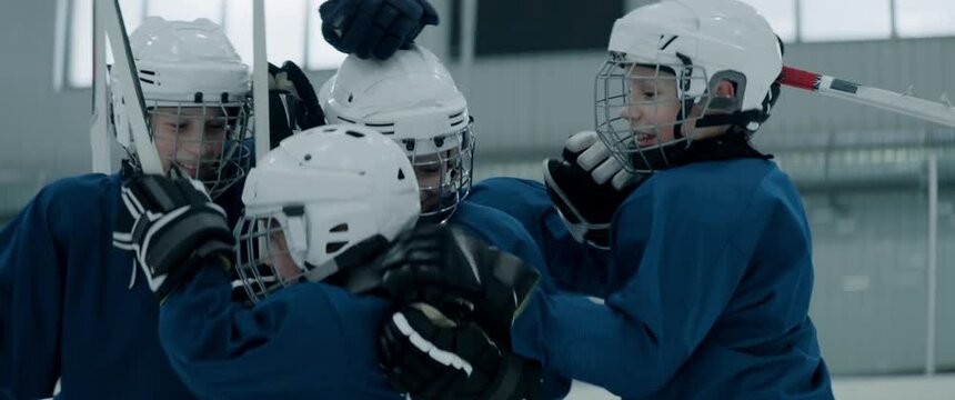 Kids cheering their teammate girl after scoring a goal during ice hockey game. Shot with 2x anamorphic lens