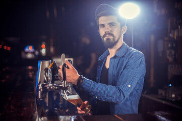 Portrait of barman makes a cocktail behind the bar