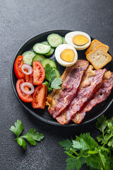 English breakfast bacon, egg, tomato, cucumber, toast bread healthy meal diet snack on the table copy space food background rustic. top view
