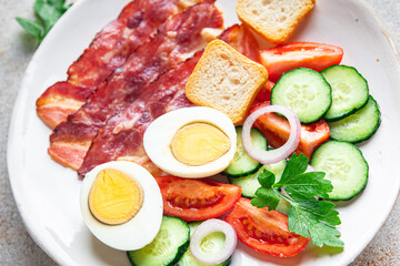 English breakfast bacon, egg, tomato, cucumber, toast bread healthy meal diet snack on the table copy space food background rustic. top view