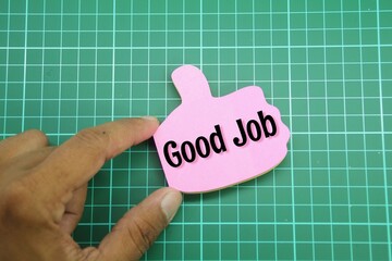 the hand holds the shape of the thumb upwards with the word good Job