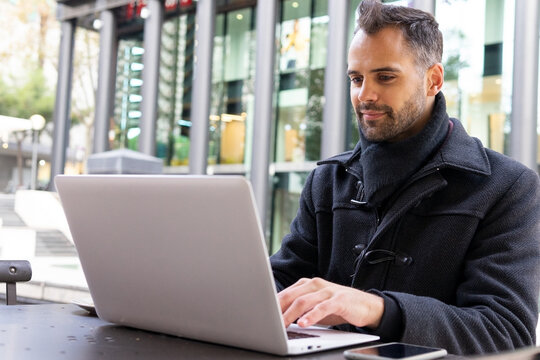 Businessman browsing laptop in cafe