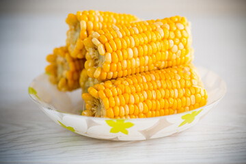 a few heads of boiled corn on a plate