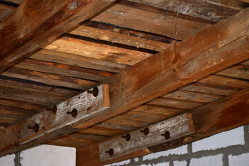 Close up of the connection of two beams with bolts and planks.
